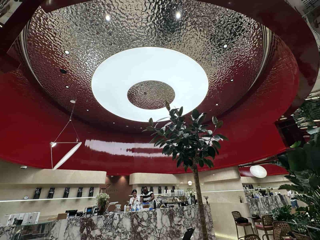 Luxury bespoke circular stretch ceiling with integrated luminous centre, decorative metallic finish and architectural lighting installed in a premium restaurant. Luxury bespoke circular stretch ceiling with integrated luminous centre, decorative metallic finish and architectural lighting installed in a premium restaurant.