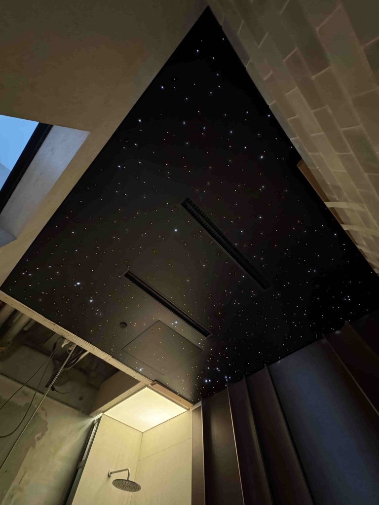 Premium black glossy ceiling with integrated star lights designed for a modern wellness and relaxation area in Dubai. Premium black glossy ceiling with integrated star lights designed for a modern wellness and relaxation area in Dubai.