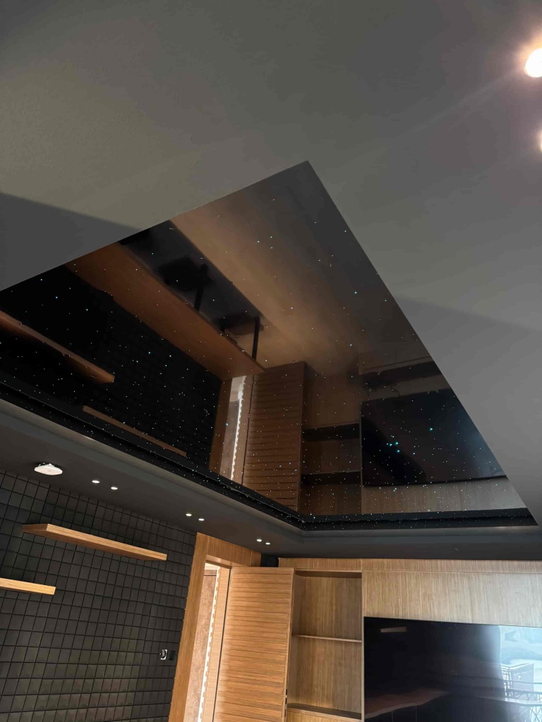 Luxury black glossy stretch ceiling with integrated fiber optic stars installed in a private gaming room at a villa in Abu Dhabi. Luxury black glossy stretch ceiling with integrated fiber optic stars installed in a private gaming room at a villa in Abu Dhabi.