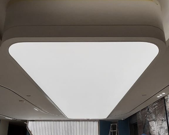 Architectural backlit ceiling installation with seamless diffused lighting in commercial interior. Architectural backlit ceiling installation with seamless diffused lighting in commercial interior.