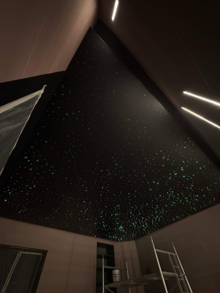 Black stretch ceiling with thousands of fiber optic stars creating a realistic night sky effect in a premium VIP lounge in Dubai. Black stretch ceiling with thousands of fiber optic stars creating a realistic night sky effect in a premium VIP lounge in Dubai.