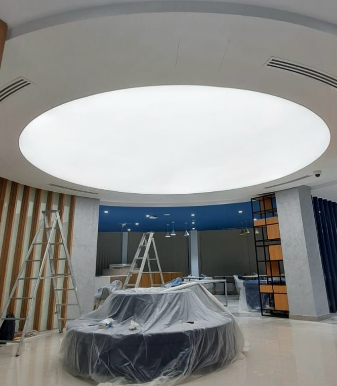 Organic-shaped waterproof illuminated stretch ceiling installed in a commercial interior, providing seamless moisture-resistant architectural lighting. Organic-shaped waterproof illuminated stretch ceiling installed in a commercial interior, providing seamless moisture-resistant architectural lighting.