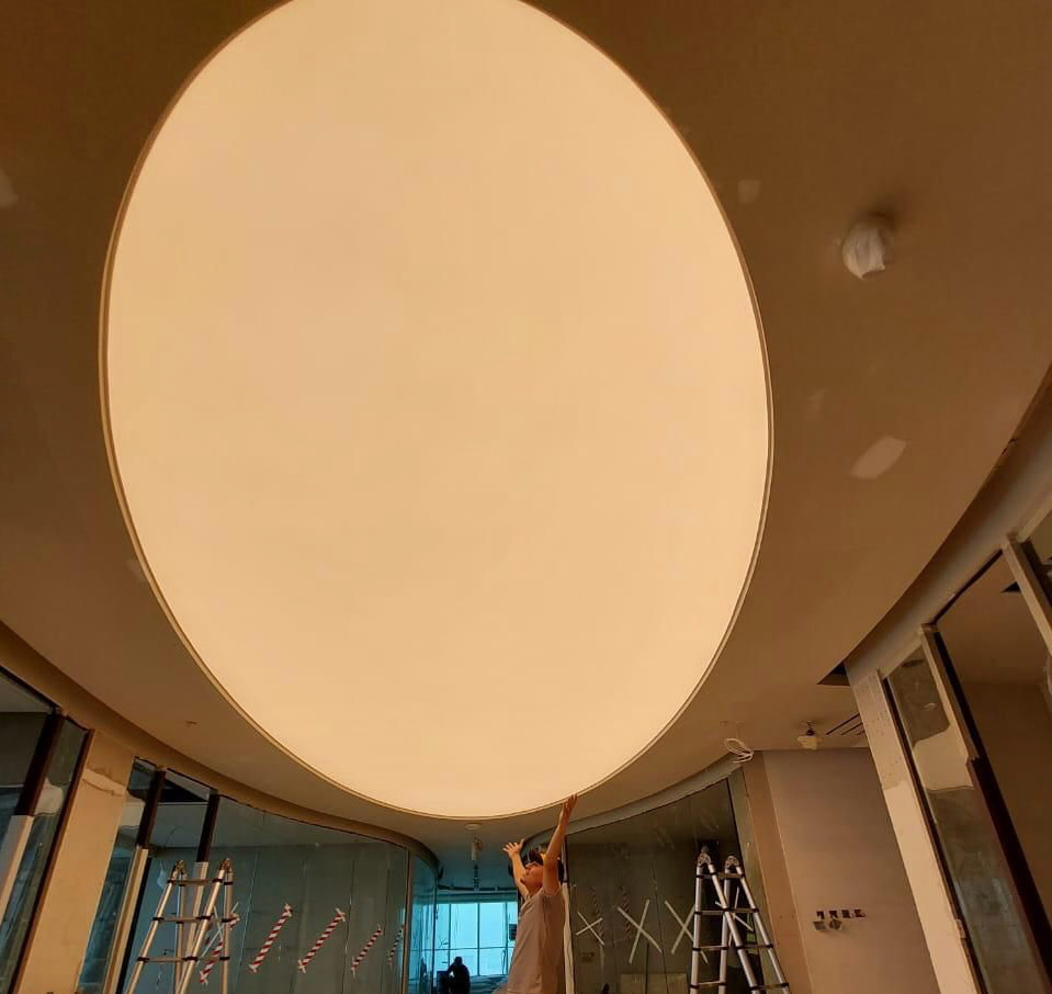 Large custom oval stretch ceiling integrated into a contemporary interior, demonstrating the design flexibility available with stretch ceiling systems. Large custom oval stretch ceiling integrated into a contemporary interior, demonstrating the design flexibility available with stretch ceiling systems.