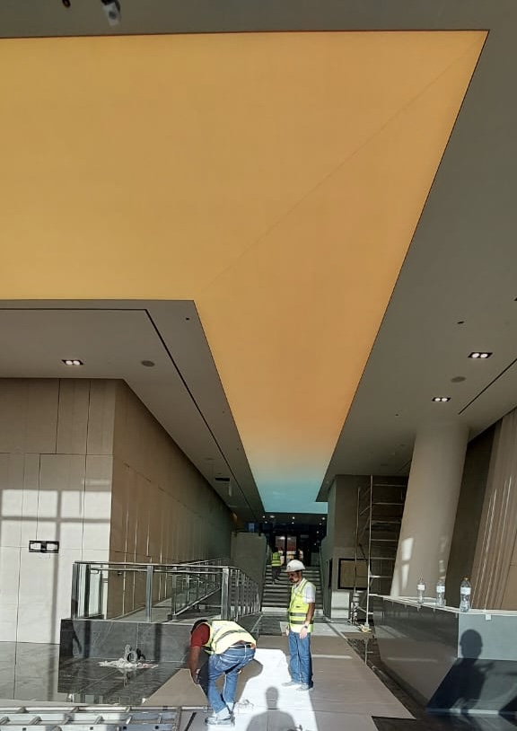 Large illuminated stretch ceiling with custom printing, 4000K LED lighting, and DALI dimming system installed in a premium lobby. Large illuminated stretch ceiling with custom printing, 4000K LED lighting, and DALI dimming system installed in a premium lobby.