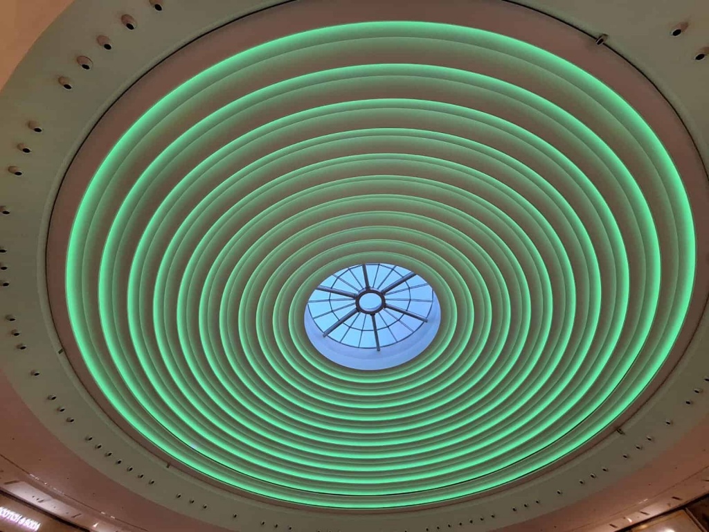 Custom RGBW circular ceiling illuminated in green with programmable LED lighting and premium stretch ceiling construction. Custom RGBW circular ceiling illuminated in green with programmable LED lighting and premium stretch ceiling construction.