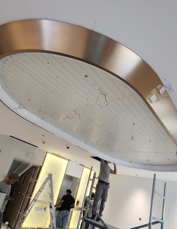 Custom shape stretch ceiling light box with 4000K LED lighting installed in a hospital entrance in Festival City Mall, Dubai. Stretch ceiling Dubai solution with uniform hospital lighting.