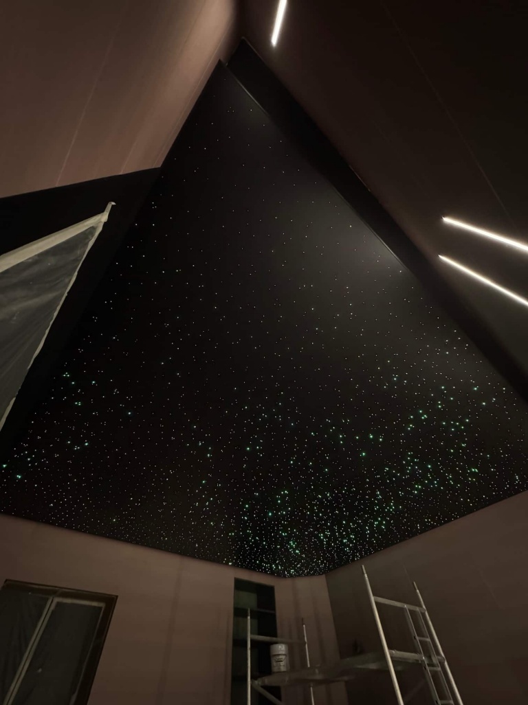 Large black stretch ceiling featuring a high-density fiber optic star field designed to create an immersive night-sky effect. Large black stretch ceiling featuring a high-density fiber optic star field designed to create an immersive night-sky effect.