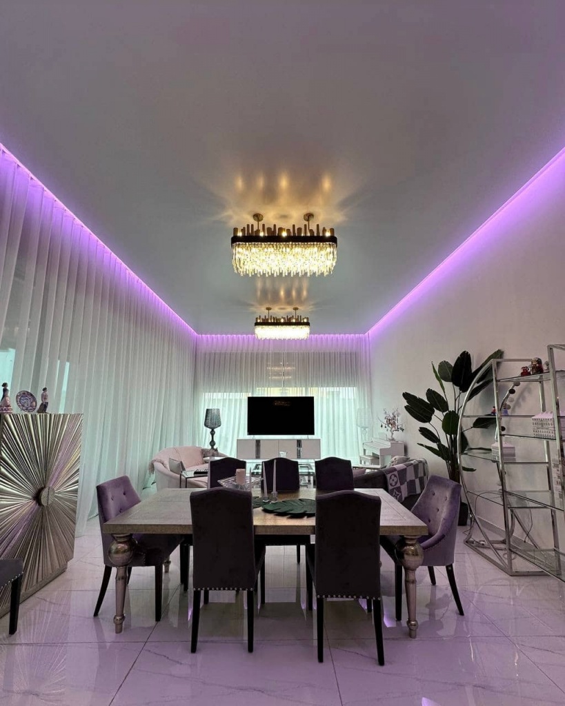 Minimalist contemporary white ceiling featuring concealed color-changing perimeter lighting and decorative chandeliers. Minimalist contemporary white ceiling featuring concealed color-changing perimeter lighting and decorative chandeliers.
