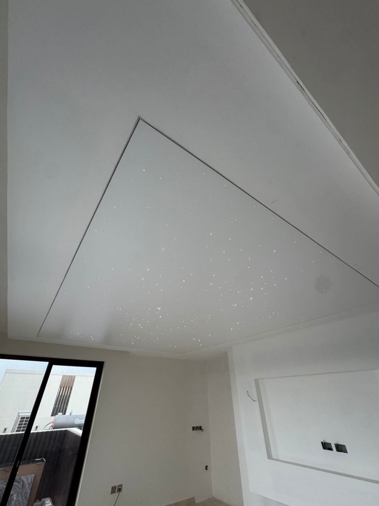 White stretch ceiling with integrated fiber optic stars, creating a subtle decorative star effect while maintaining a clean contemporary appearance. White stretch ceiling with integrated fiber optic stars, creating a subtle decorative star effect while maintaining a clean contemporary appearance.