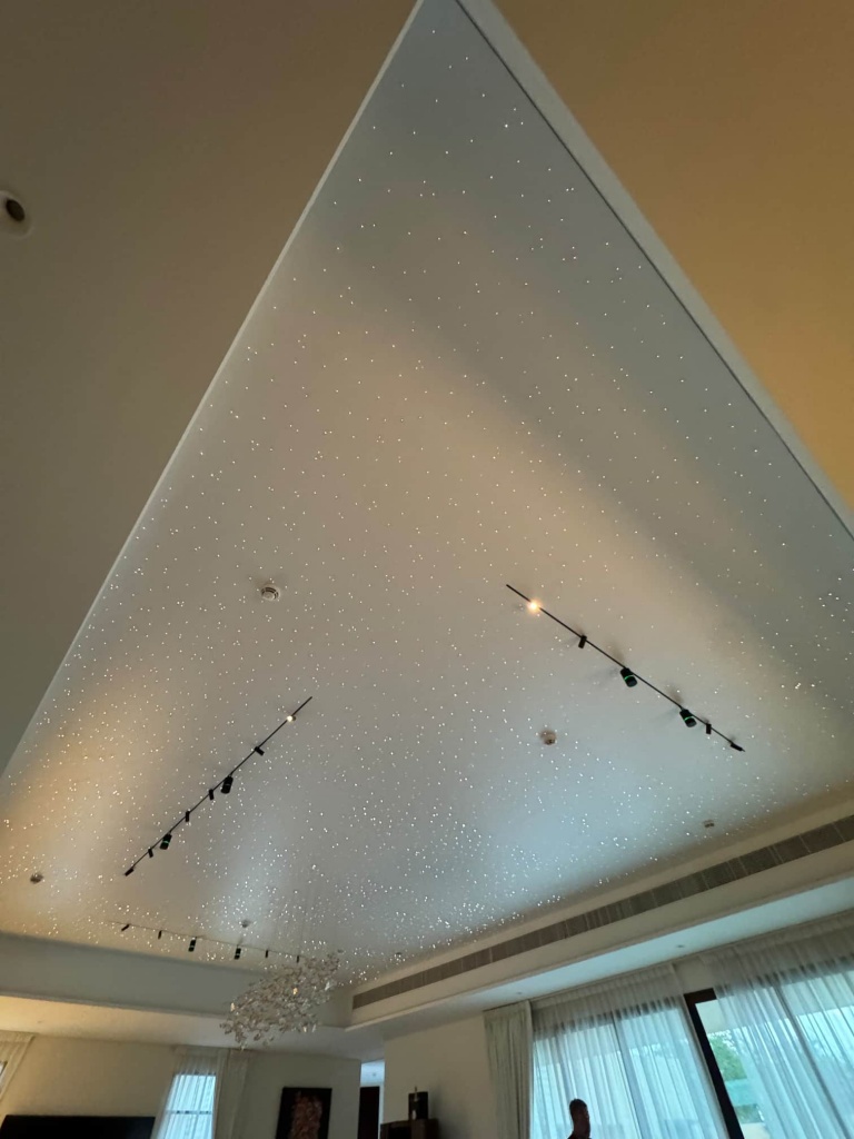 Minimalist magnetic track lighting installed within a white stretch ceiling featuring hundreds of fiber optic stars for a clean and contemporary luxury interior. Minimalist magnetic track lighting installed within a white stretch ceiling featuring hundreds of fiber optic stars for a clean and contemporary luxury interior.
