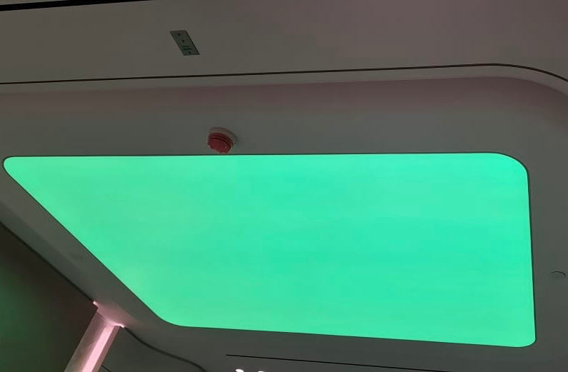 Modern RGBW stretch ceiling illuminated in green, demonstrating seamless colour-changing architectural lighting for a commercial interior. Modern RGBW stretch ceiling illuminated in green, demonstrating seamless colour-changing architectural lighting for a commercial interior.