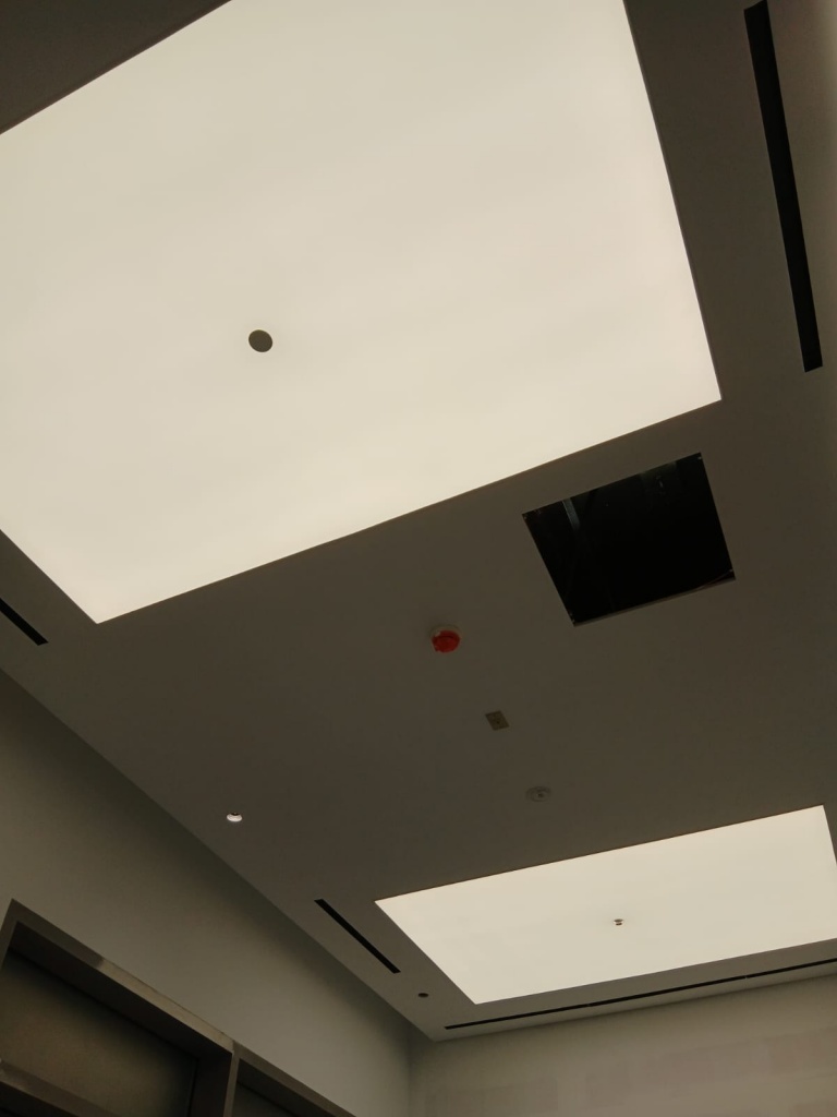Backlit waterproof stretch ceiling installed in a hospital environment with uniform LED illumination and hygienic design. Backlit waterproof stretch ceiling installed in a hospital environment with uniform LED illumination and hygienic design.