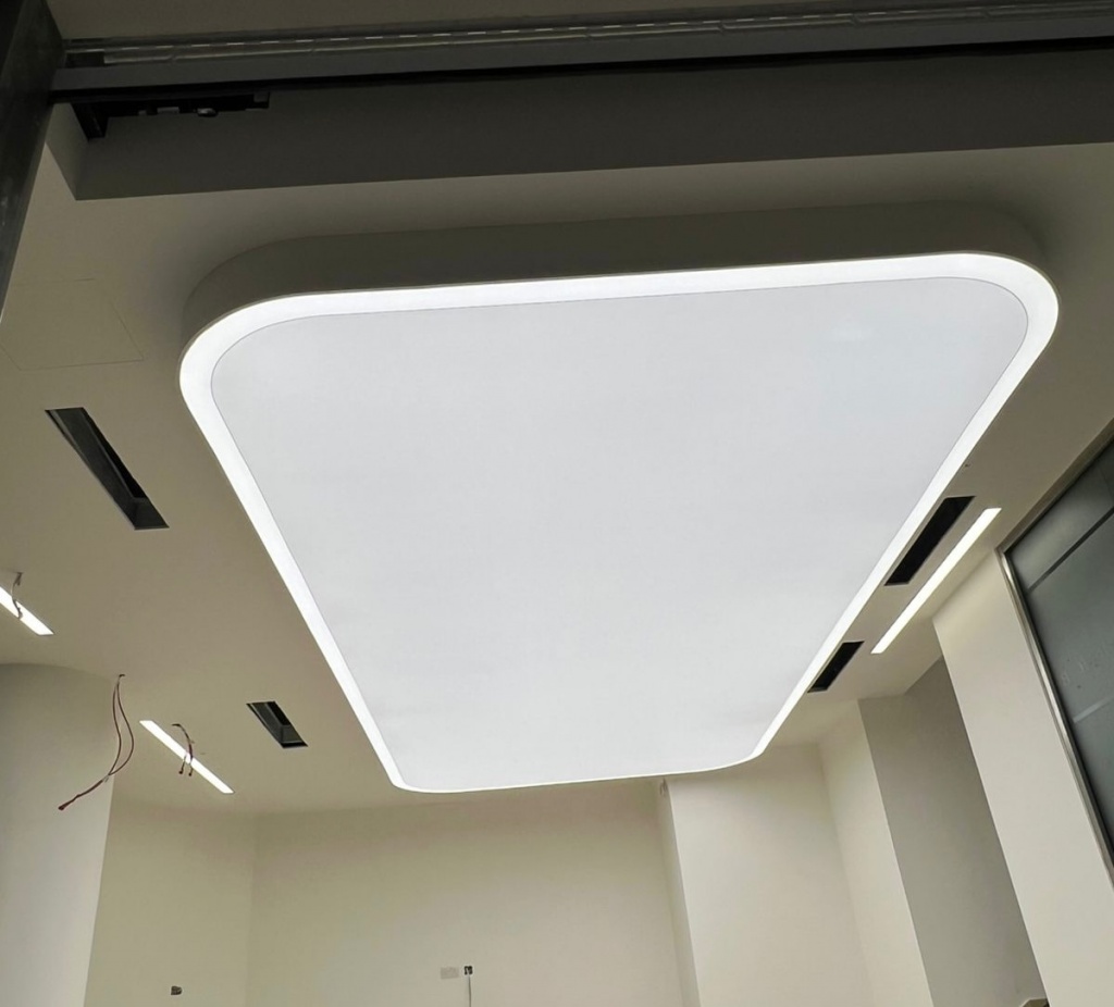 Stretch ceiling light box with 4000K LED lighting installed in Bentley showroom cellar in Dubai. Uniform backlit ceiling solution for luxury interiors.