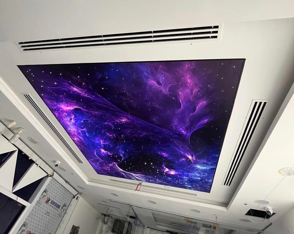 Custom UV printed illuminated stretch ceiling with a galaxy artwork for a commercial interior. Custom UV printed illuminated stretch ceiling with a galaxy artwork for a commercial interior.