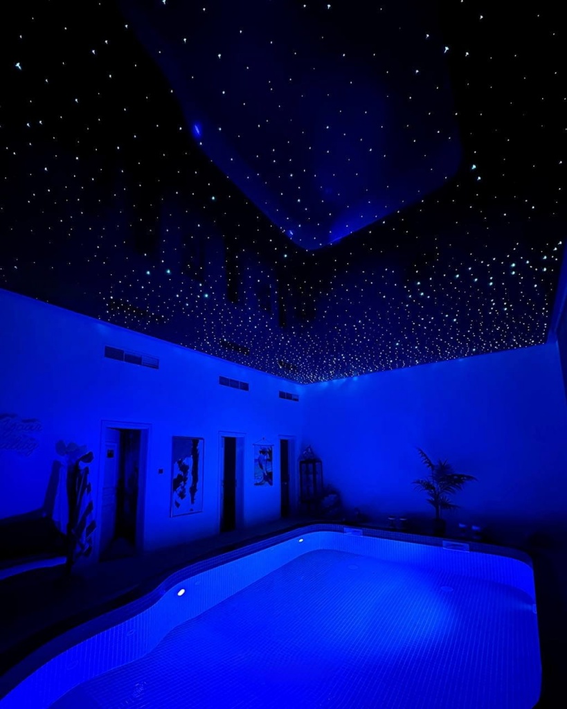 Premium black stretch ceiling with thousands of fiber optic stars designed for a private wellness area. Premium black stretch ceiling with thousands of fiber optic stars designed for a private wellness area.