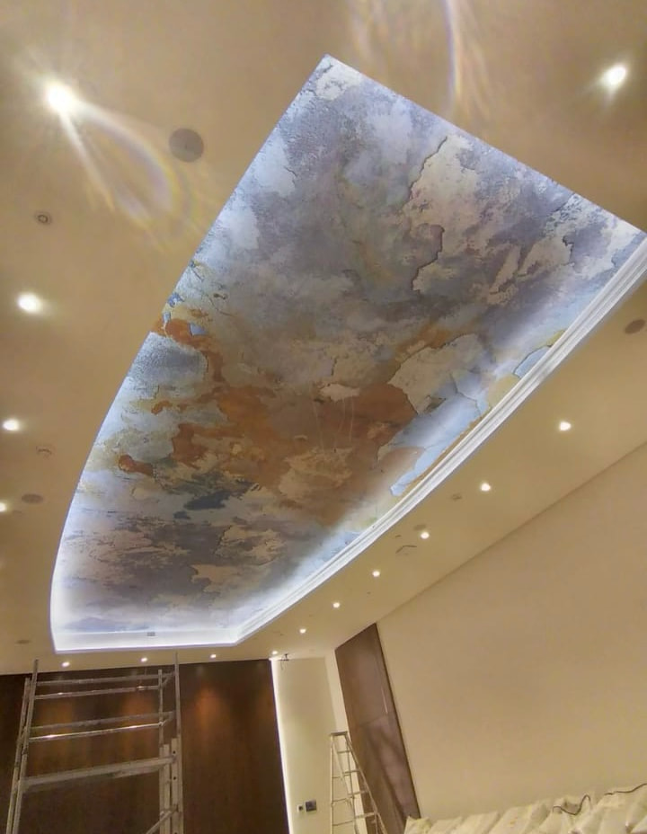 Custom elongated stretch ceiling installation with a decorative printed finish and integrated architectural lighting. Custom elongated stretch ceiling installation with a decorative printed finish and integrated architectural lighting.