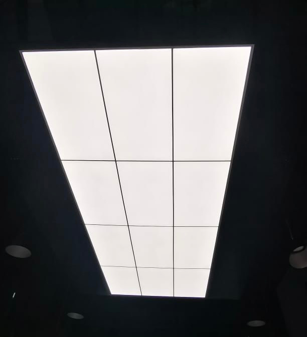 Large rectangular luminous ceiling divided into architectural sections, demonstrating integration of stretch ceiling technology with modern lighting design. Large rectangular luminous ceiling divided into architectural sections, demonstrating integration of stretch ceiling technology with modern lighting design.