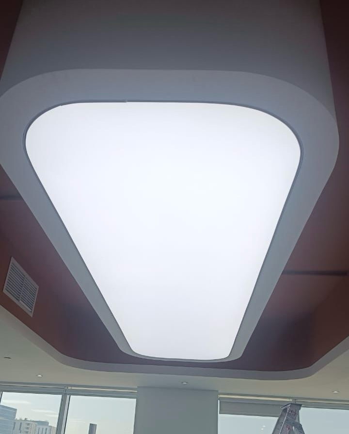 Large rectangular illuminated ceiling panel integrated into a minimalist modern interior using stretch ceiling technology. Large rectangular illuminated ceiling panel integrated into a minimalist modern interior using stretch ceiling technology.